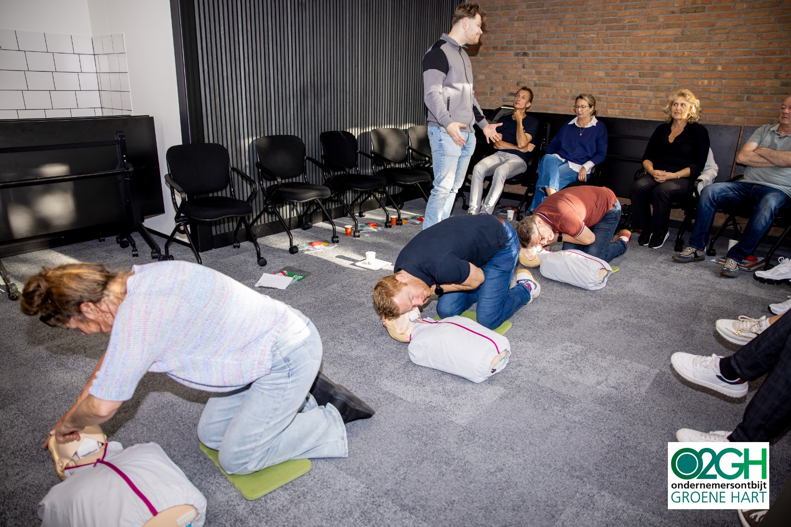 Deelnemer oefent borstcompressies onder begeleiding van een trainer