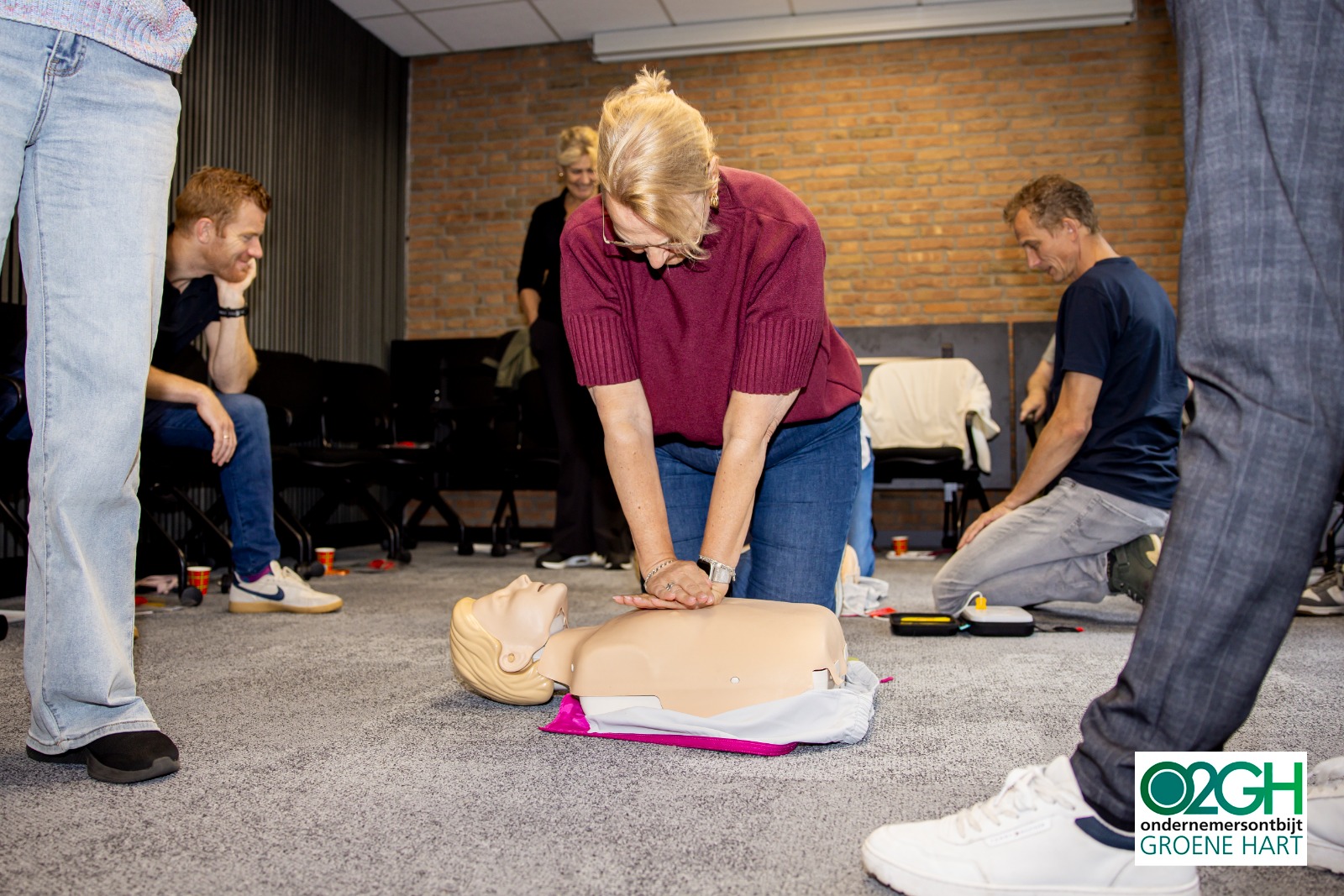 Deelnemer oefent borstcompressies terwijl de groep meekijkt